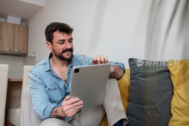 Bearded man working at home on iPad